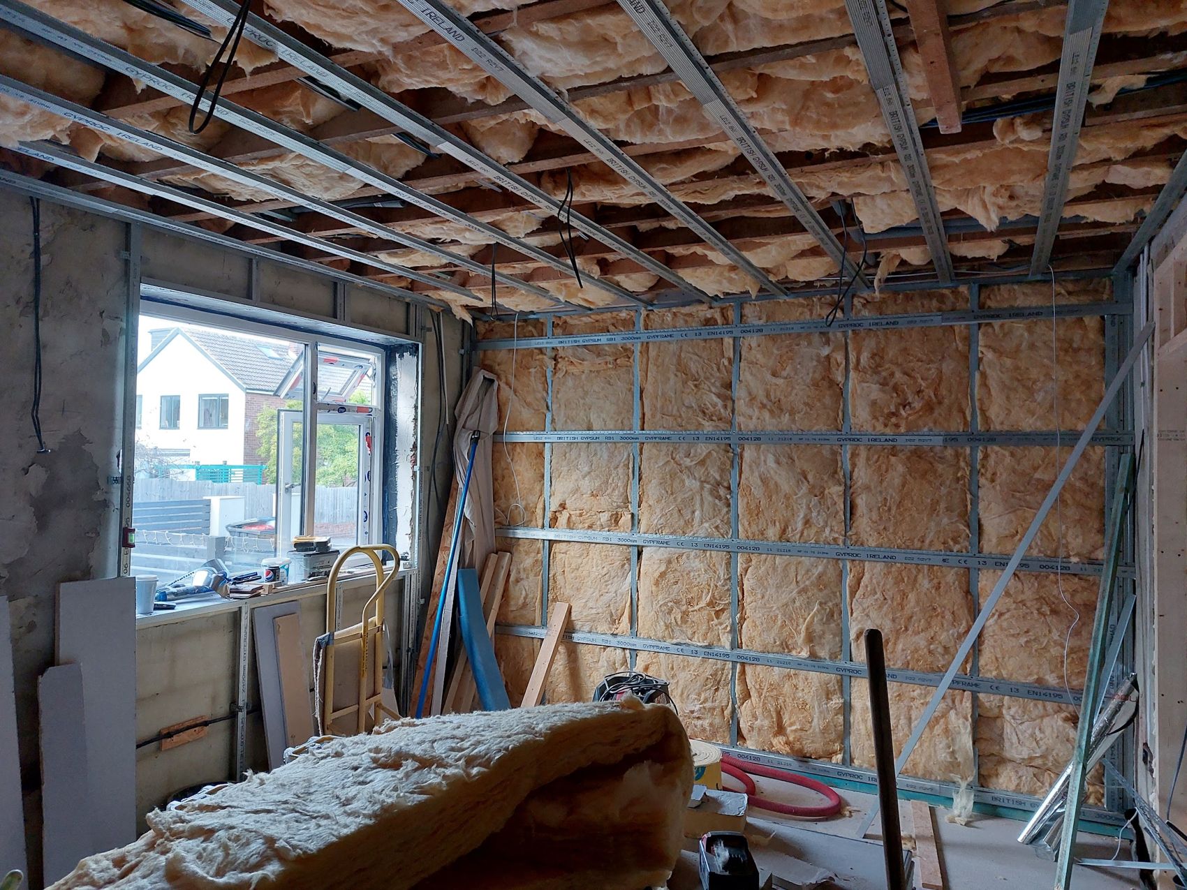 A room framed out and fully filled with mineral wool insulation to walls and ceiling before boarding
